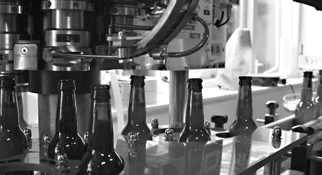 Bierflessen worden gevuld op onze eigen semi-automatische bottellijn