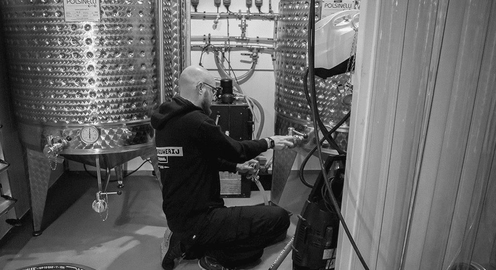 De brouwer aan het werk tussen de fermentatie- en lagertanks