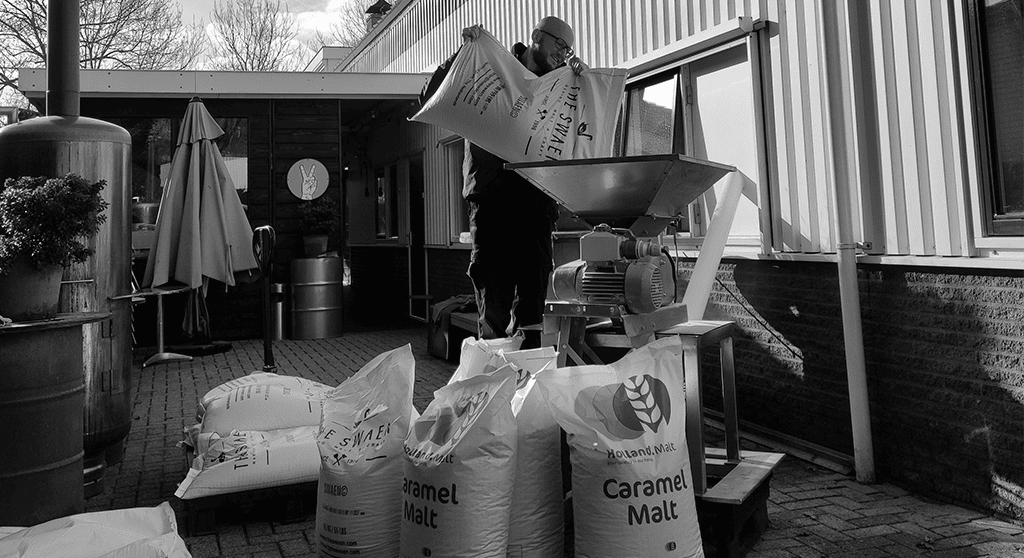 Schrootmolen met zakken caramelmout ervoor